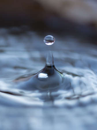 Drops from the tap fall into a bucket of water. Tap water.の写真素材