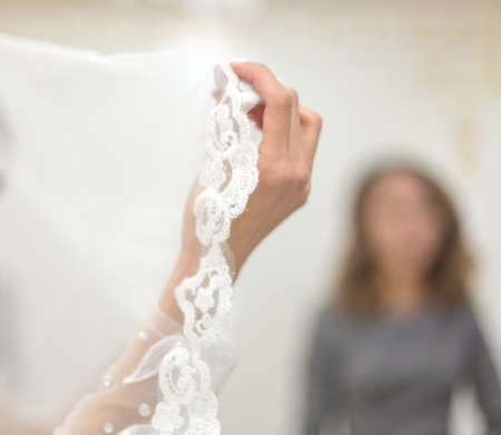 Close up of bride's hands holding white dresses