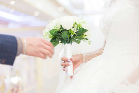 closeup of bride hands holding beautiful wedding bouquetの写真素材