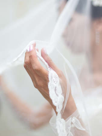 Close up of bride's hands holding white dressesの写真素材