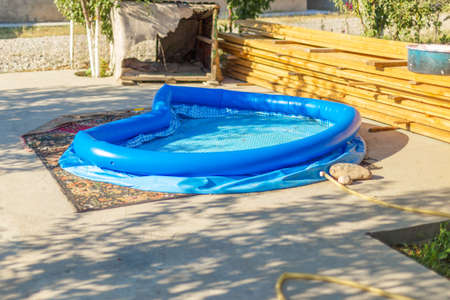 Blue inflatable rubber pool in the courtyard of a country houseの写真素材