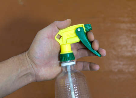 yellow water spray in hand.の写真素材
