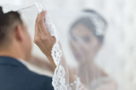 Close up of bride's hands holding white dressesの写真素材