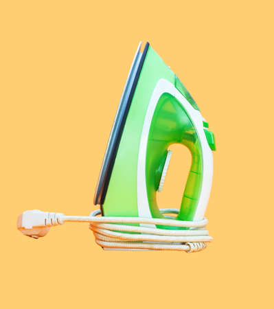 Iron, iron for ironing on a yellow background.の写真素材