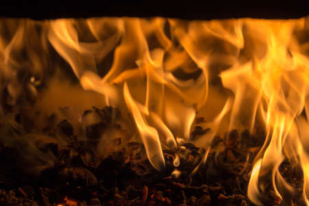 Fire flame burning glowing on black dark background, hot heat energy fuel fire motion pattern abstract texture.の写真素材