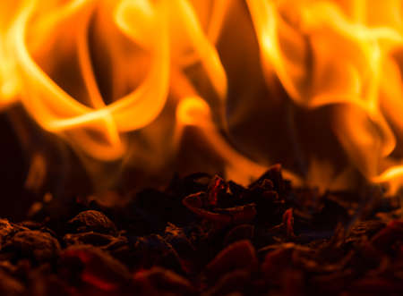 Fire flame burning glowing on black dark background, hot heat energy fuel fire motion pattern abstract texture.の写真素材