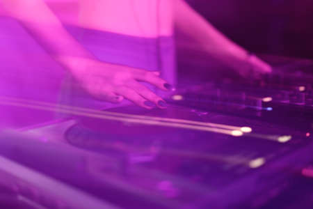 DJ mixing in a karaoke bar. Soft focus on hand - a concept of entertainment, youth, entertainment and relaxationの写真素材