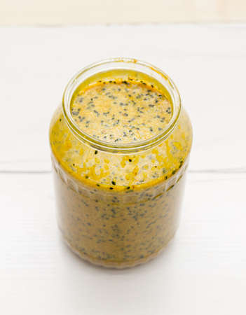 Therapeutic mixture with honey from sesame seeds, turmeric, caraway seeds and ginger on a glass jar on the tableの写真素材