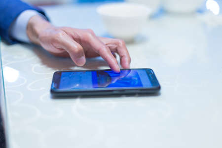 A man sits in a cafe and reads SMSの写真素材