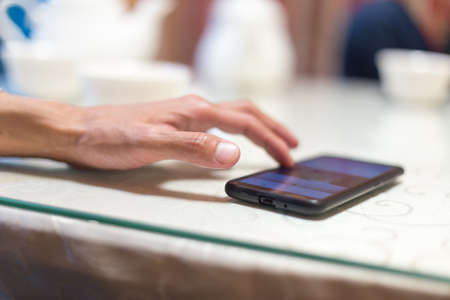 A man sits in a cafe and reads SMSの写真素材