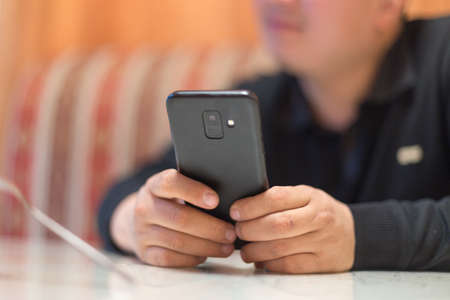 A man sits in a cafe and reads SMSの写真素材