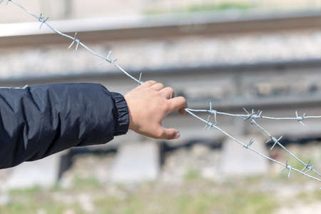 Hand hold barbed wire. Conceptual scene.の写真素材