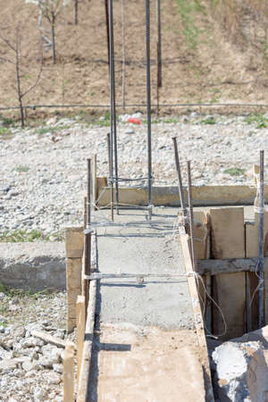 Formwork for the foundation of the house. Close-up of the foundation of a house made of concrete formwork blocks filled with mortar and reinforcementの写真素材