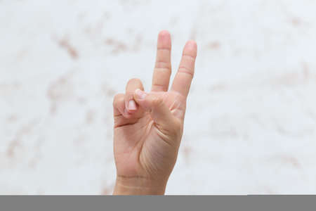 Hand shows number two, isolated backgroundの写真素材