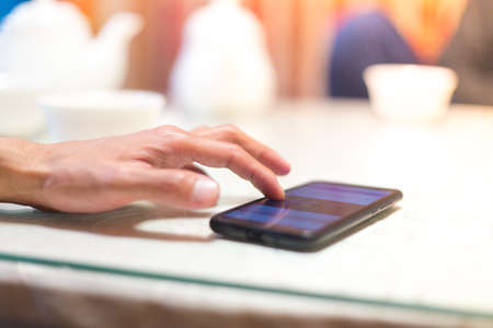A man sits in a cafe and reads SMSの写真素材