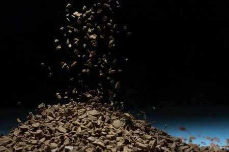 Flying coffee beans isolated on black background. Roasted coffee beans against a flash of lightの写真素材