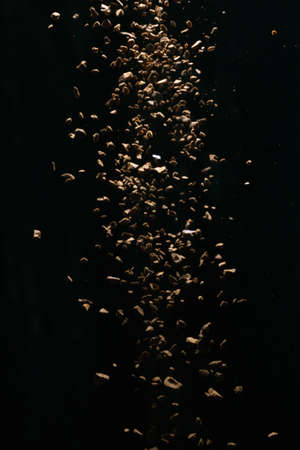 Flying coffee beans isolated on black background. Roasted coffee beans against a flash of lightの写真素材