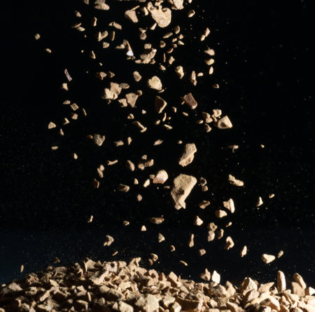 Flying coffee beans isolated on black background. Roasted coffee beans against a flash of lightの写真素材