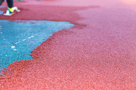 red rubber covering for the playground, the master smoothes the soft rubber crumb by hand. Soft covering for sports floors. Rubber mulch for safety and injury prevention.の写真素材