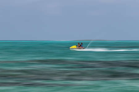 Mother and daughter riding a jet ski in colorful green water, Bahamas の写真素材