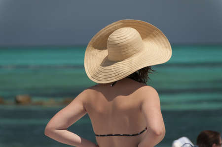 Girl wearing a hat looking out at the Atlantic Ocean, Bahamasの写真素材