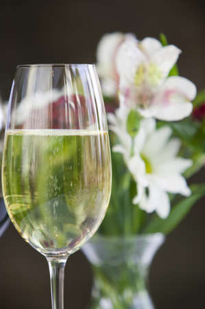 Glass of white wine and flowers still life の写真素材
