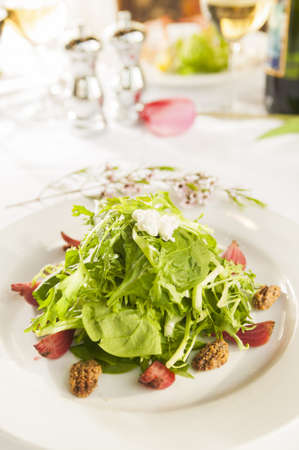 Fancy healthy salad on a white plate in a fancy restaurant setting の写真素材