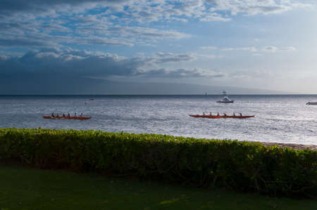 Two native Hawaiian boats rowing past at sunset on Maui, Hawaii, USAの写真素材