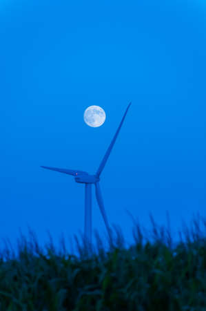 Moonrise over a lone wind turbine in Dexter Minnesota USAの写真素材