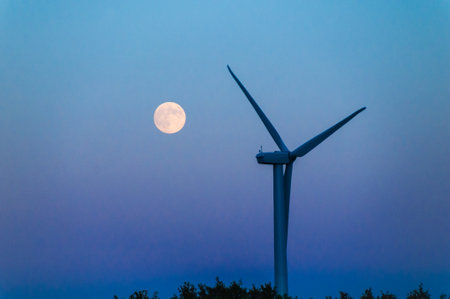 Moonrise over a lone wind turbine in Dexter Minnesota USAの写真素材