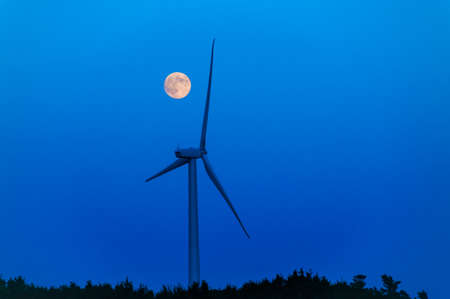 Moonrise over a lone wind turbine in Dexter Minnesota USAの写真素材