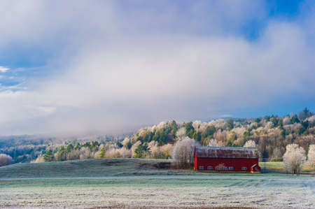 Red barn on a frosty autumn morning in the New England town of Stowe Vermont USAの写真素材