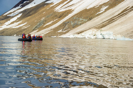 HORNSUND, SVALBARD, NORWAY â JULY 26, 2010: Tourists from the National Geographic Explorer cruise ship on inflatable rafts in the Artic Ocean exploring a fijord in the Arctic.のeditorial素材