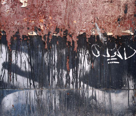 old black metal panel, with rusty on the top, with white graffiti letters, lines and grungy scraches - texture with a grunge steampunk aesthetic backgroundの写真素材