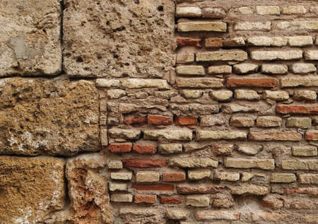 old wall background texture with ancient stones damaged bricks in red, white, brown and orange...