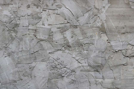 irregular surface of cement with spatula texture - messy gray wall backgroundの写真素材