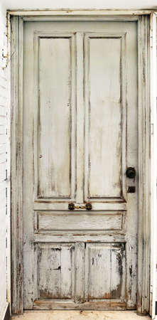 Old worn white door damaged and with ancient texturee from an abandoned buildingの写真素材
