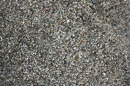 texture of a natural ground with small gray pebbles and sand - park or beach backgroundの写真素材