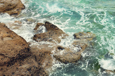 Atlantic ocean sea waves with foam, crashing against the rocks of the coast - nice turquoise blue...