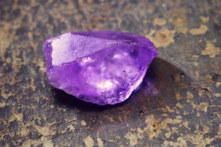 shiny purple raw gem or crystal - beautiful gemological background treasure