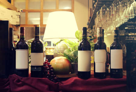 beautiful composition with wine bottles with blank customizable labels, tomatoe, grapes, vegetables and lounge lamp - still life wallpaperのeditorial素材