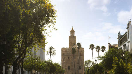 Cityscape of Seville in Spain, with the tower of gold (torre del oro) in the background, a blue sky,...