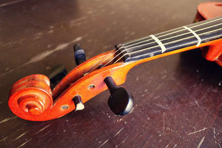 closeup of an old violin with pegs and strings with beautiful shapes - music symbol for the...