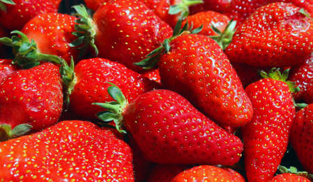 natural ripe strawberries background pattern - closeup healthy realfood of mature fruit for a red and green backgroundの写真素材