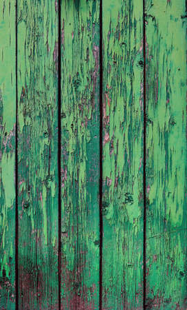 weathered wooden boards painted with green chipped color from an abandoned doorの写真素材
