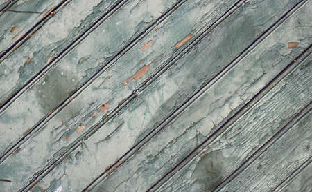 old worn wooden surface with dirty oblique boards, rough texture with scratches and blue peeling paintの写真素材