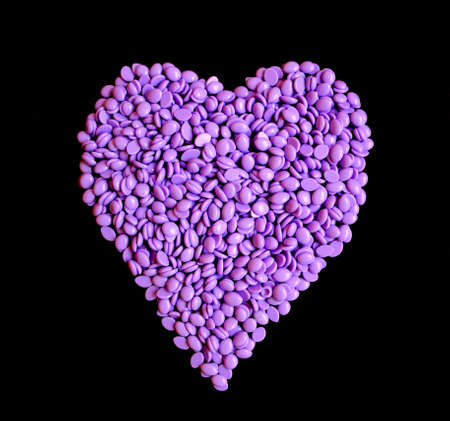 depilatory purple wax with the shape of heart on black blank backgroundの写真素材