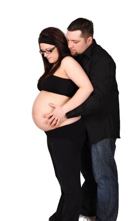happy expectant couple standing admiring bare pregnant tummy. isolatedの写真素材