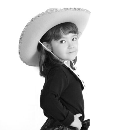 sweet little cowgirl in hat posing in black and white. isolated on whiteの写真素材