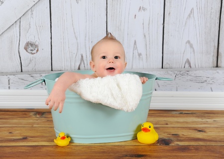 sweet baby boy playing peek-a-boo in washtubの写真素材